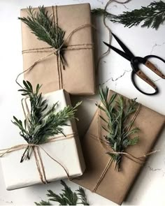 two wrapped presents tied up with twine and pine needles, sitting next to each other