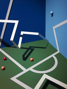 two balls are in the air on a basketball court with white lines and blue walls