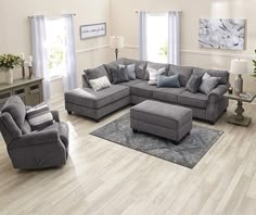 a living room filled with lots of furniture on top of a hard wood floored floor