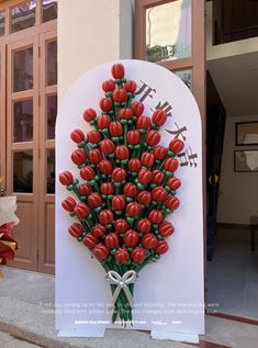 a bunch of red flowers on display in front of a building