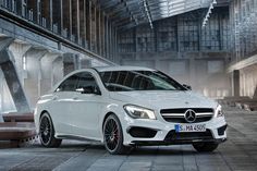 a white mercedes cla parked in front of a building