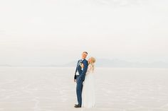 a bride and groom standing in the middle of a salt flat