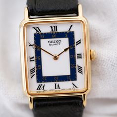 Seiko tank vintage watch for women in gold. Japanese quartz. 20mm perfectly sized for a 90s ladies vintage watch. White and blue dial. This exclusive vintage Seiko women's watch embodies the essence of the 90s era with its all-original design and impeccable Japanese craftsmanship. A unique and beautiful timepiece in amazing condition made for generations to come. Sleek lines, flawless proportions and refined dials make this timepiece an embodiment of elegance rarely found in today's watches. 90s Vintage Watch Women, Seiko Tank, Seiko Vintage, Cocktail Watch, Woman In Gold, Vintage Watches Women, Small Women, Leather Watch Strap, Watch Gifts