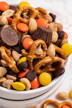 a white bowl filled with candy and pretzels