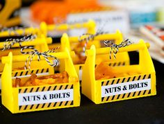 small yellow boxes with nuts and bolts tied to them on a table in front of other food items