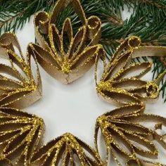 some gold glittered ornaments hanging from a christmas tree