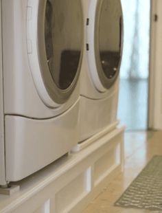 two white washers sitting on top of a counter next to each other in front of a door