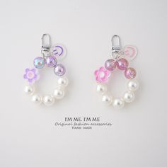 two charms with flowers and pearls on them