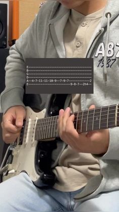 a young man playing an electric guitar in front of a computer screen with the caption above it