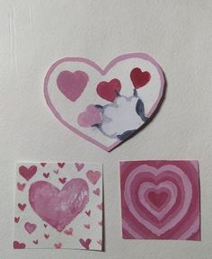 three pieces of paper with hearts painted on them, one is pink and the other is white