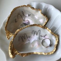 two oysters with wedding rings in them on a white plate that says mr and mrs