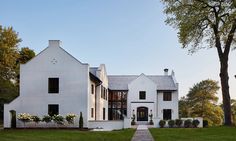 a large white house sitting on top of a lush green field