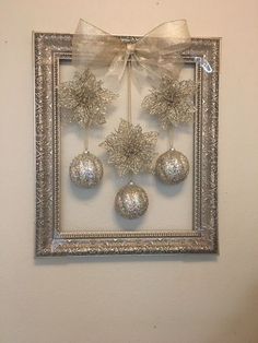 a silver frame with ornaments hanging on the wall