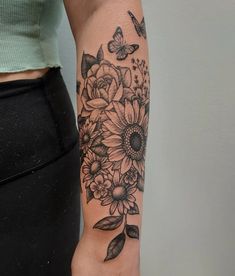 a woman's arm with flowers and butterflies on it