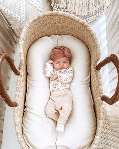 a baby is sleeping in a wicker cradle