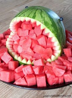 a watermelon and melon cut in half on a plate with other pieces