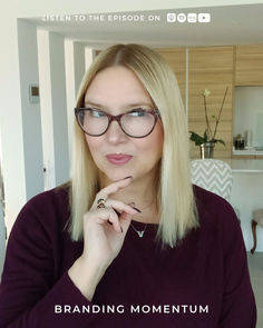 a woman with glasses is looking at the camera and has her hand on her chin