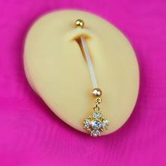 a pair of dangling earrings on a pink background