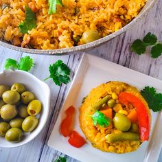 two plates with rice, olives and peppers on them next to a bowl of green beans