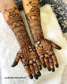 two hands with henna tattoos on them