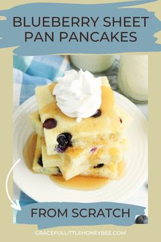 blueberry sheet pan pancakes on a white plate with whipped cream and blueberries in the background