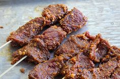 several skewers of meat sitting on top of a table