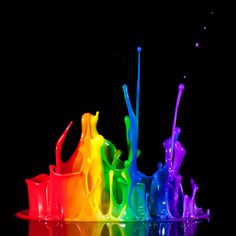 rainbow colored liquid pouring into a black background