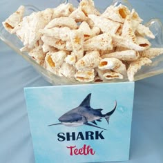 a bowl filled with crackers next to a card that says shark teeth on it