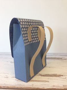 a blue paper bag sitting on top of a wooden table next to a white wall