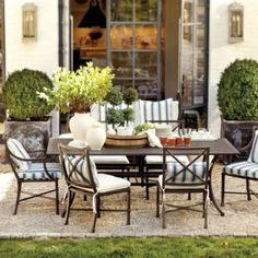 an outdoor dining table with blue and white striped chairs