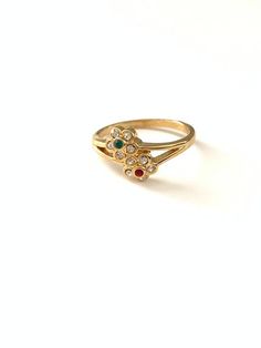 Vintage Dainty Red Green Clear Rhinestone Crystal Flower Ring, Vintage Gold Tone Flower Stacking RingSweet dainty new old stock flower rings, in very good vintage condition. All items such as boxes, coins, etc., in photos are NOT included with the jewelry, they are props being used for display. Important: Please read all shop policies prior to purchase.The below is a brief overview, to view full shop policies please go to the homepage of the shop and scroll to the bottom and they are listed in f Vintage Flower Toe Ring For Gift, Vintage Flower Toe Ring, Vintage Wedding Toe Ring With Flower Design, Vintage Wedding Flower Toe Ring, Vintage Jeweled Round Rings, Vintage Jeweled Rings, Vintage Gold Rings With Flower Shape, Vintage Multi-stone Birthstone Ring As Gift, Vintage Multi-stone Birthstone Promise Ring