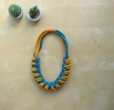 9mm padded cotton rope necklace. The necklace is suitable for all seasons and gives an original touch to different clothing styles. The appearance is simple but of great impact. The item is light and pleasant to wear. The necklace is worked using four intertwined peacock blue and mustard cotton cords and is closed with mustard cotton thread. Length: 28cm Circumference: approximately 56cm Thickness: 3cm Textile Necklace, Gift Idea For Women, Colorful Textiles, Rope Necklace, Peacock Blue, Cotton Rope, Clothing Styles, Original Gift, Woven Cotton