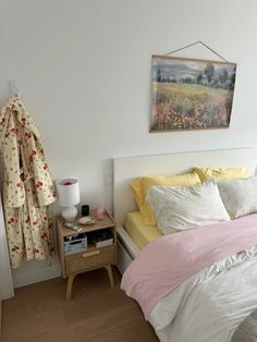 a bedroom with a bed, nightstand and painting on the wall