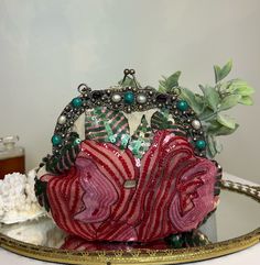 Vintage silk beaded evening handbag with sterling silver stone encrusted frame, Christiana. This stunning silk bag features a bead and sequin design in shades of red, pink, and green, sterling silver frame with stones around the top of one side, a kiss lock, silver chain handle, ivory satin lining, and one interior pocket. Great condition; no flaws to note. Label reads, Christiana Clutch Measurements: 9"long 9" tall All the items I list in my store are vintage or antique. Some treasures will show signs of wear or age, and I will always do my best to list any flaws, marks or honest repairs.  Please carefully study all the item photos for condition.  If you'd like more images or details about an individual item please get in touch and I will be happy to help you. Wedding Bags, Silk Bag, Sequin Design, Evening Handbag, Wedding Bag, Accessories Bags Purses, Silver Frame, Shades Of Red, Vintage Silk