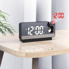 an alarm clock with red numbers on it sitting on a table