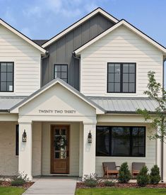 a white two story house with black trim and windows on the front door is shown