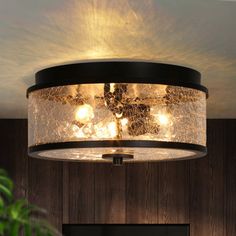 a light fixture in a living room with wood paneling on the walls and ceiling