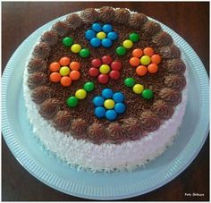 a cake with chocolate frosting and colorful candies on top is sitting on a plate