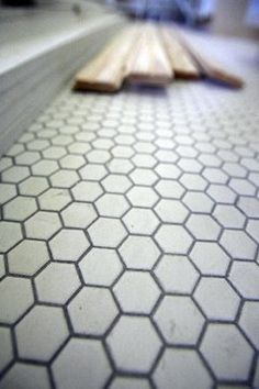 the floor is white and has hexagonal tiles on it with wooden planks