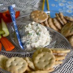 a plate with crackers, carrots, celery and cheese