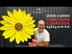 a man sitting in front of a giant yellow flower