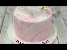 a pink marbled cake with white flowers on top