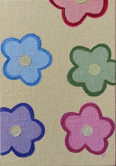 four different colored flowers are shown on a piece of fabric with buttons in the middle