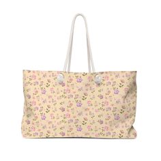 a pink flowered bag with white handles on the front and side, it has flowers all