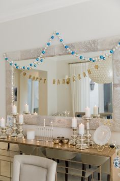 a table with candles and decorations in front of a mirror