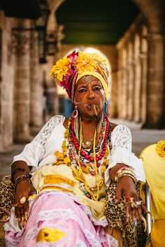 an old woman in costume sitting on a bench