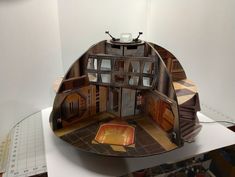 a model of a house made out of wood and other items on a table top