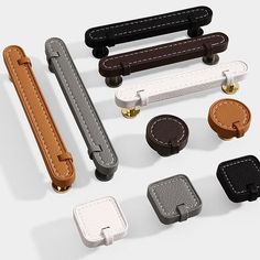 an assortment of leather and metal objects on a white surface, including handles for the watch