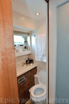 a bathroom with a toilet, sink and shower stall in the corner next to it