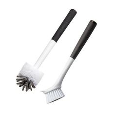 two white and black cleaning brushes on top of each other, one with a long bristles